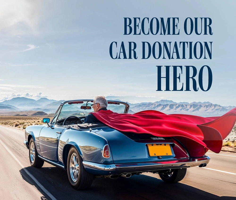the driver of a car driving on the road is wearing a superman cape