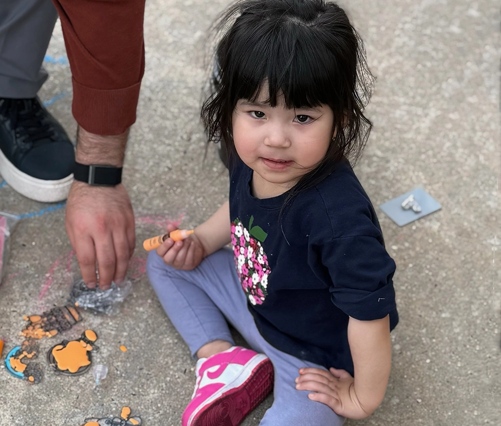 little girl creating art on a sidewalk